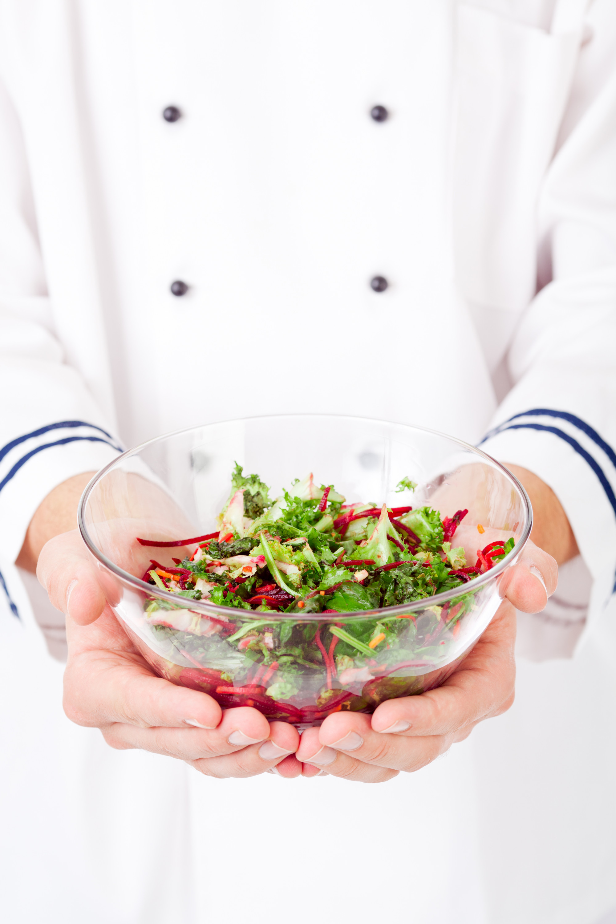 chef hands holding bowl of salad